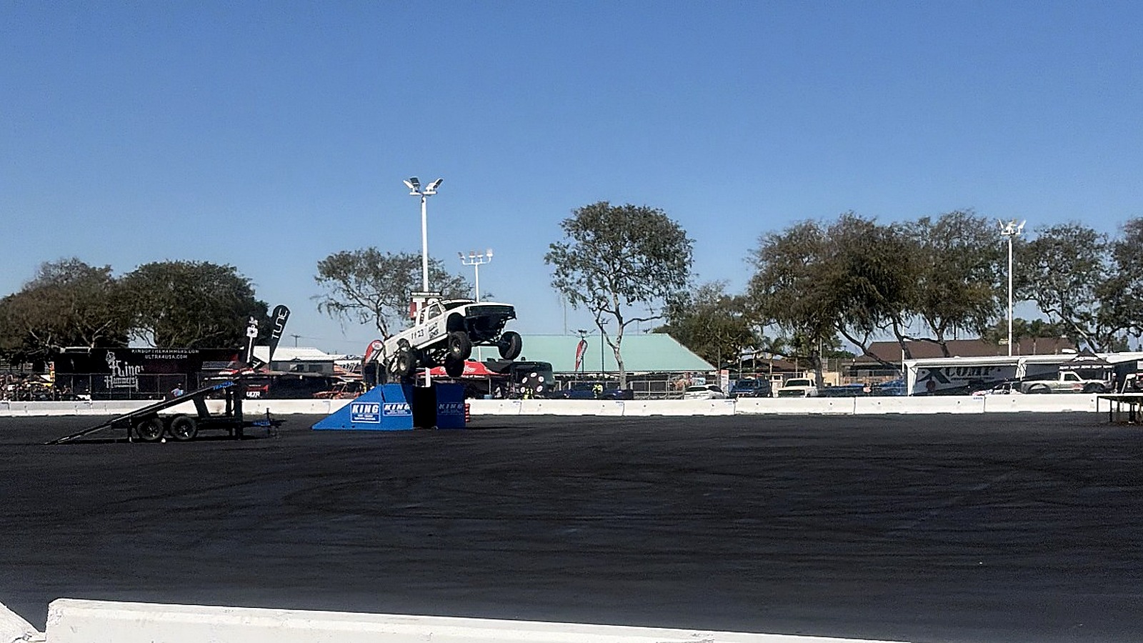 White OBS Ford prerunner launching off a ramp at the 2026 King Shocks Off-Road Expo